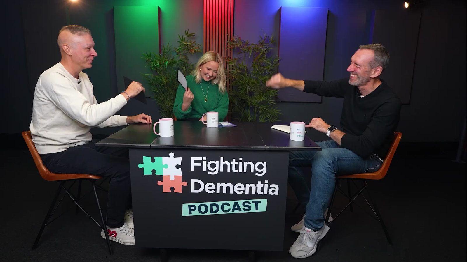 Three people talking around the Fighting Dementia Podcast desk in the studio